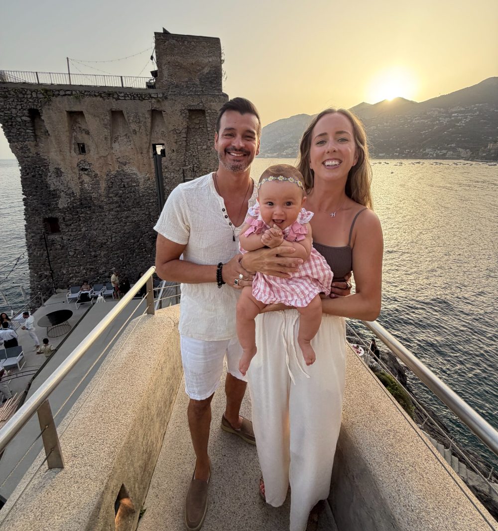 Zoli and Colombe with their baby daughter at sunset on the Amalfi Coast
